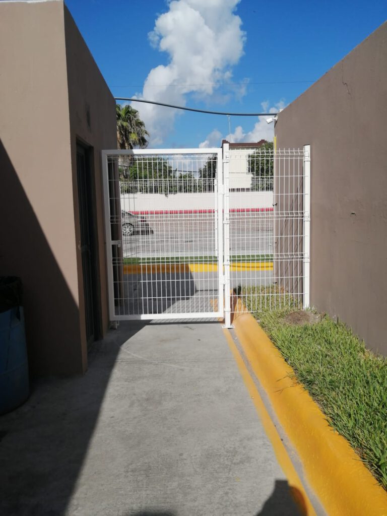 Puerta hecha de reja color blanca para control de accesos